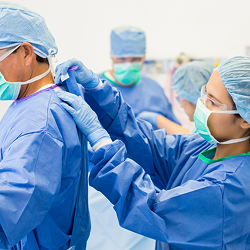 Team assisting each other with medical uniforms