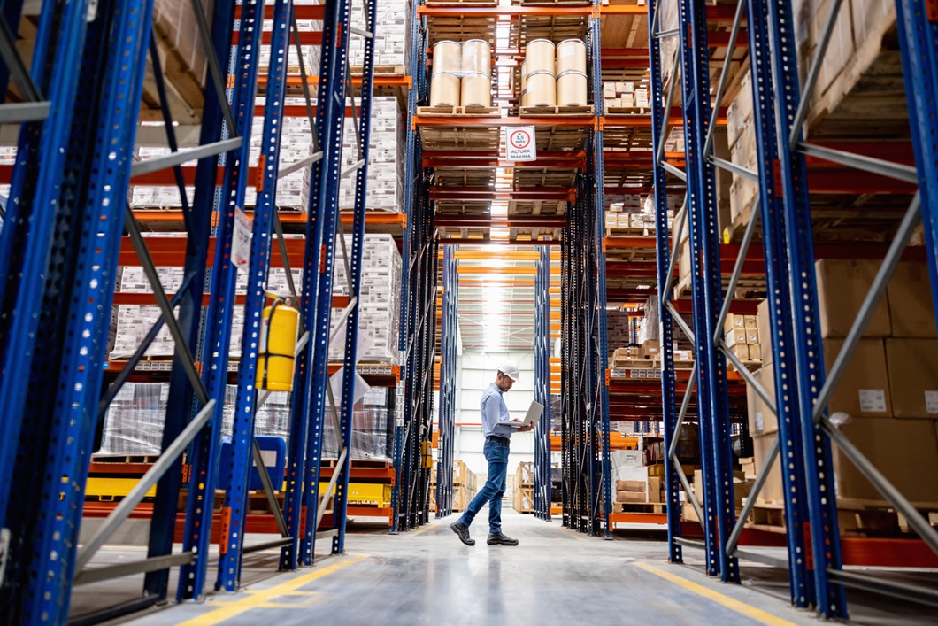 a worker stands in a large warehouse